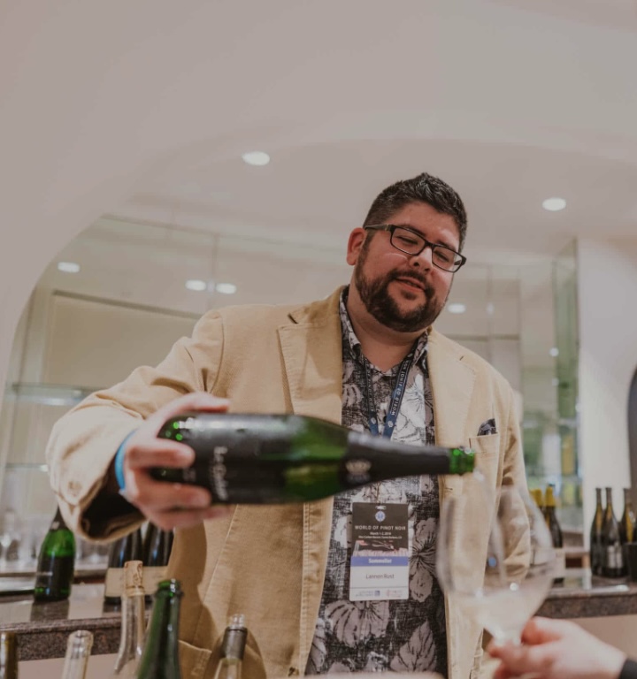 Lannon Rust, founder of Rust Wine Company, pouring wine at a tasting